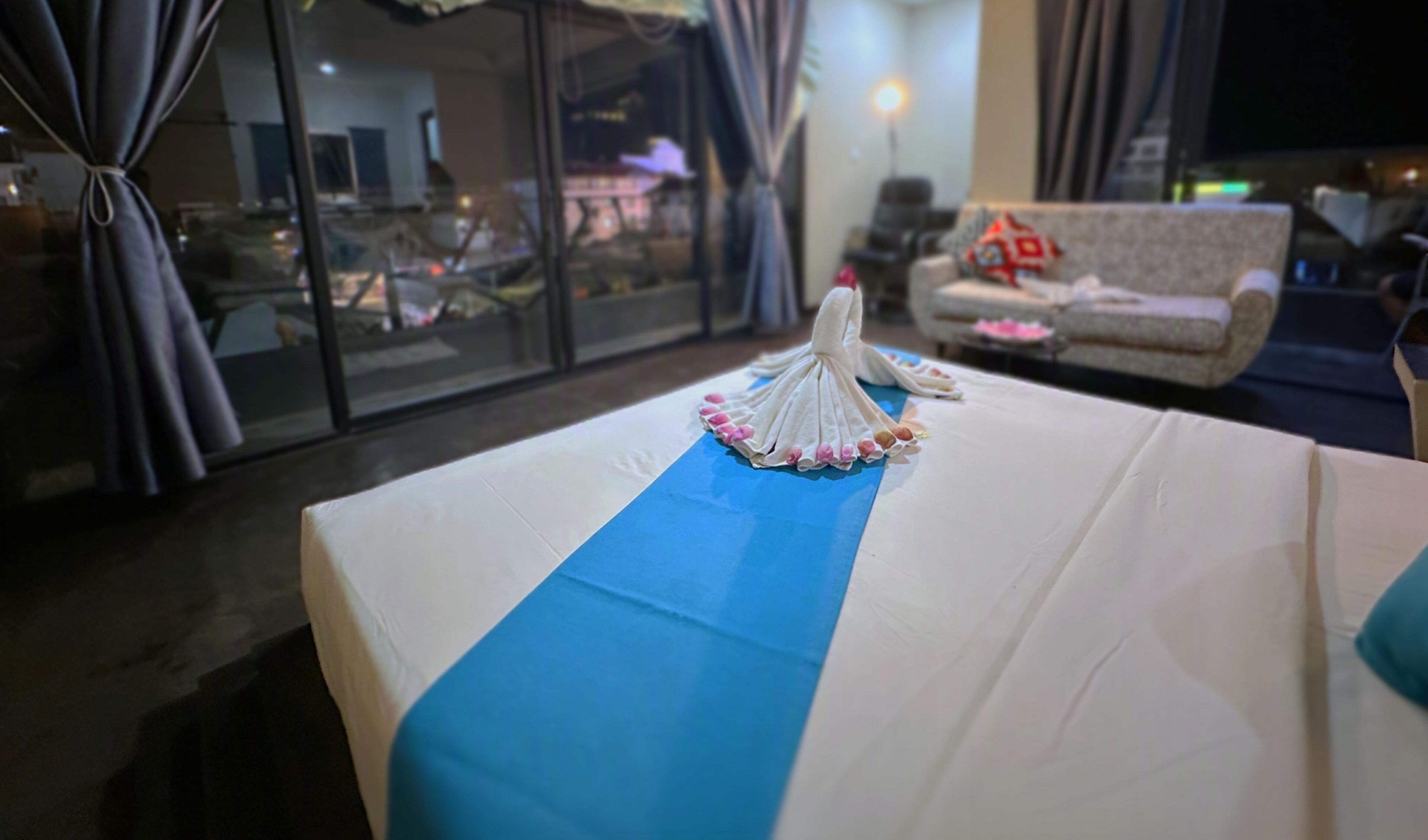 Habitació d'hotel amb un llit, una vista per una finestra gran i un sofà.