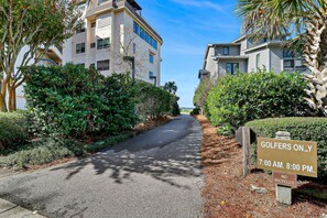 A residential street with a sign indicating 'GOLFERS ONLY' from 7:00 AM to 8:00 PM.