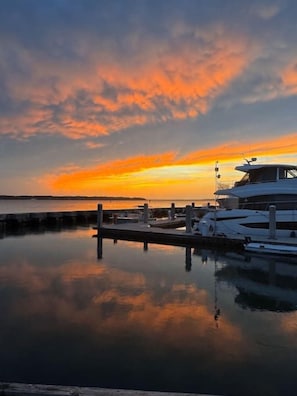 A marina with a docked yacht and calm water reflecting the sky.