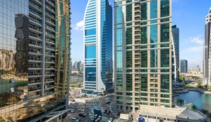 A modern urban area with high-rise buildings, a busy intersection, and a body of water.