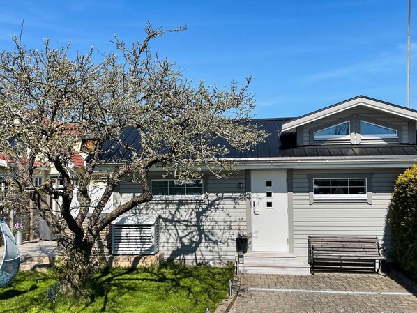 A residential house with a sloped roof, a front porch, and a tree in the yard. - 4 Star Holiday Home in Karlskrona (Hasslö)