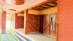 Uma galeria coberta com portas de madeira e chão de azulejos.