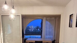 Una sala moderna con un sofá, una mesa de comedor y un balcón con vistas.