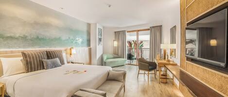 Habitación de hotel moderna con una cama grande, un escritorio con silla, televisión y balcón con vistas.