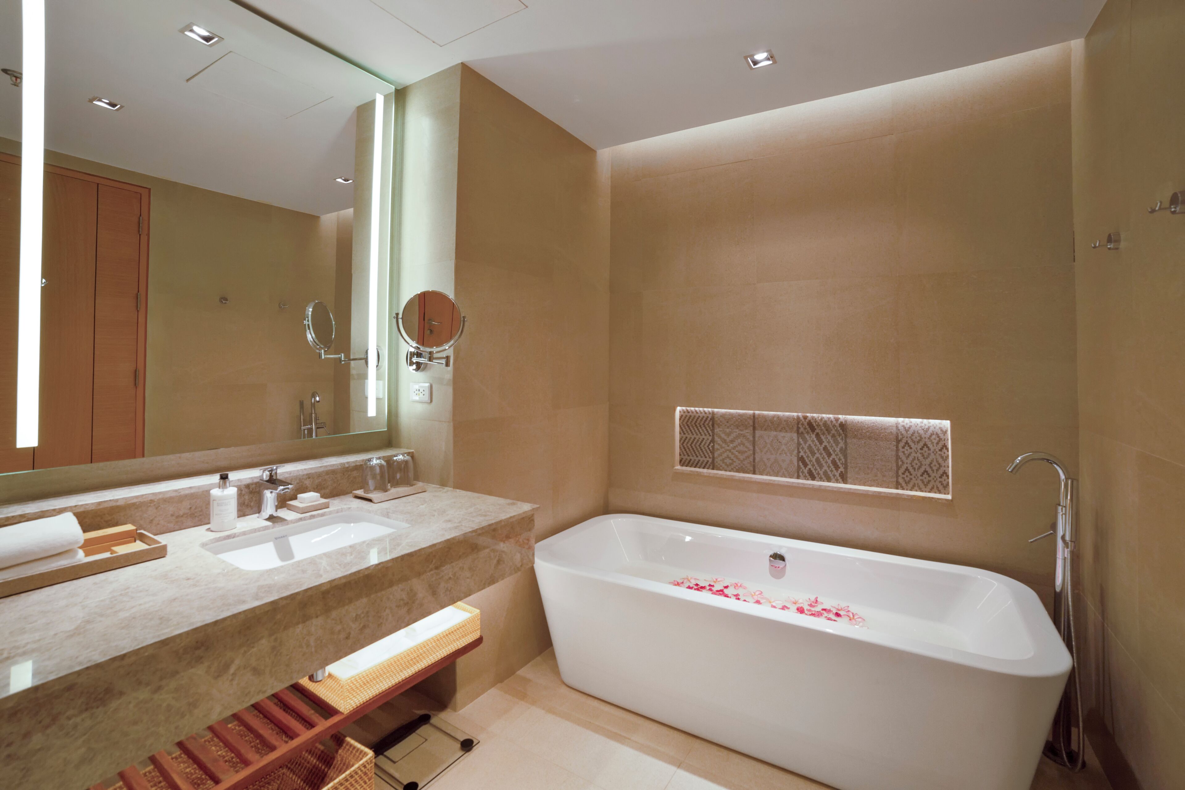 Une salle de bain moderne avec une grande baignoire, deux lavabos et un miroir.