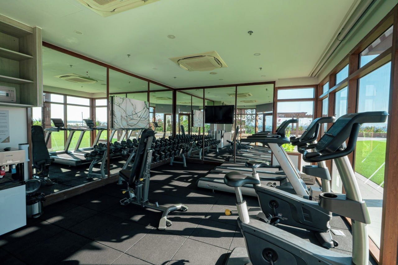 A gym with treadmills, elliptical machines, and free weights.