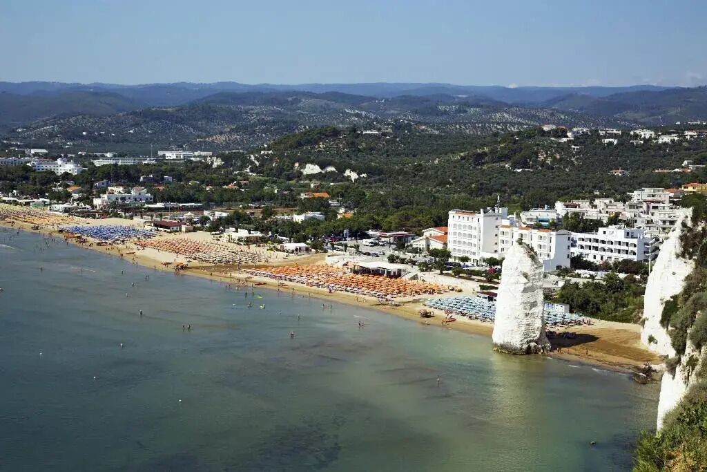 Un pueblo costero con playa, edificios y acantilados.