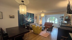 Una sala de estar moderna con comedor, que incluye un sofá, sillas, una mesa de centro y una mesa de comedor.