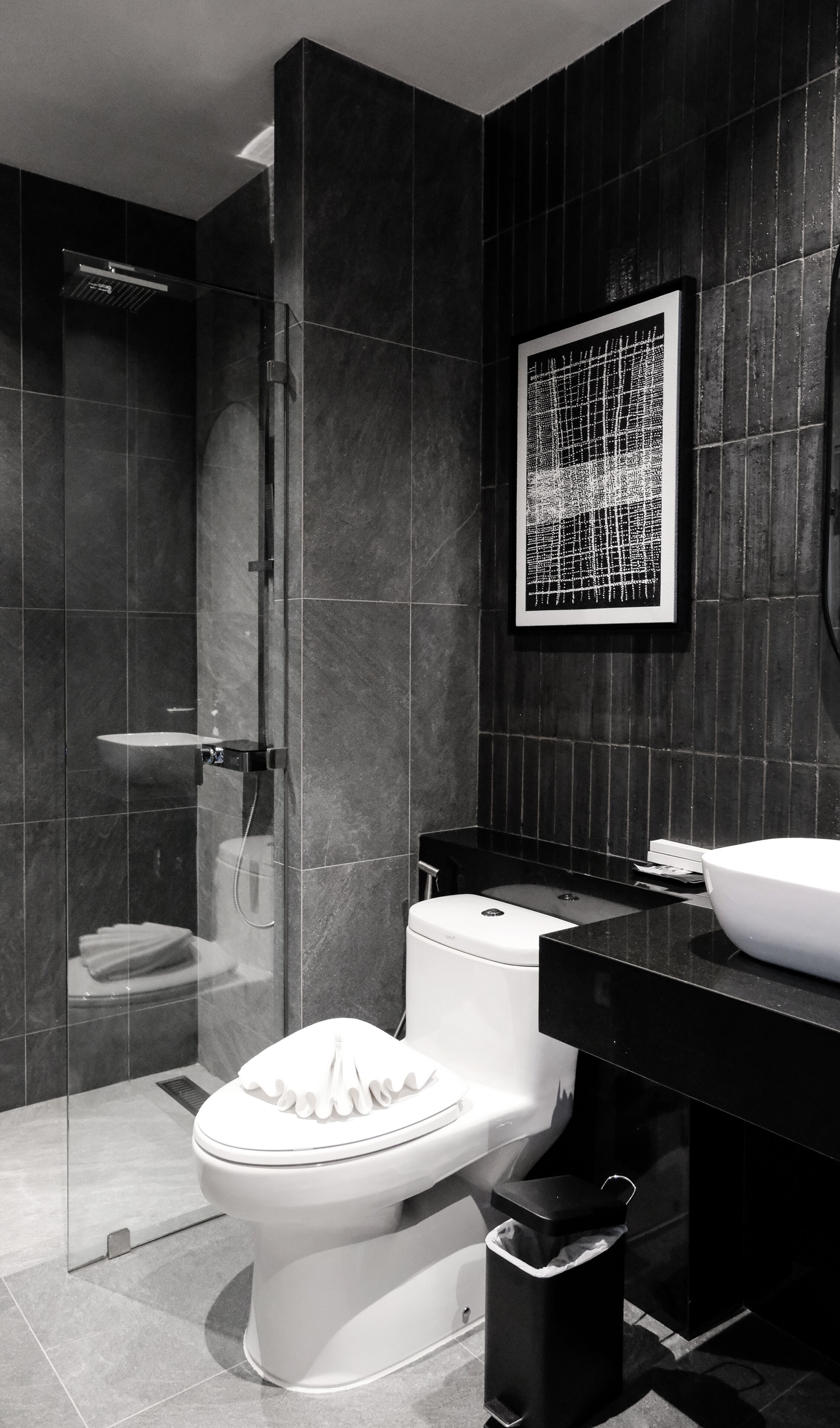 A modern bathroom with a toilet, bidet, and a glass-enclosed shower.