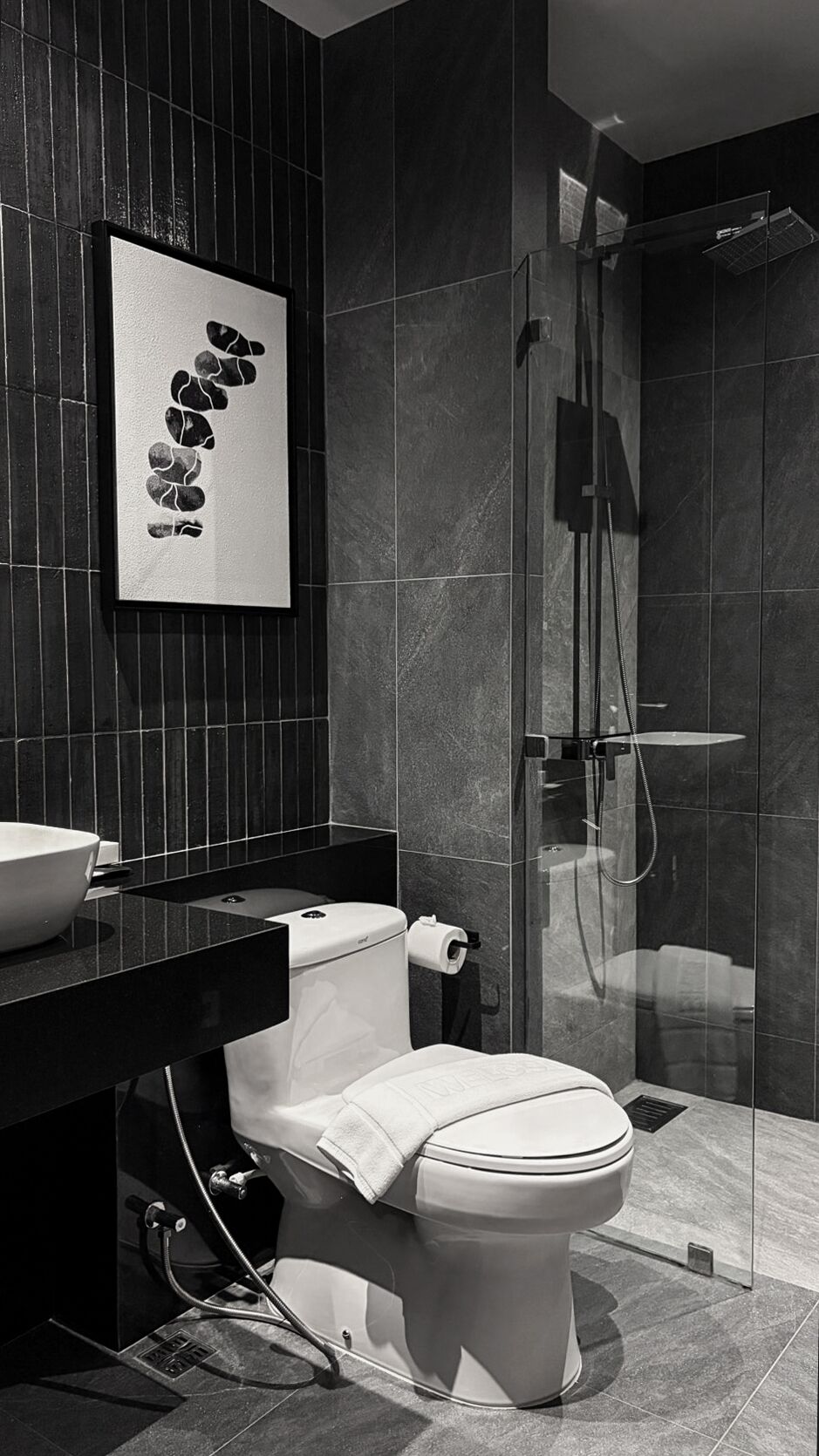 A modern bathroom with a toilet, a sink, and a glass-enclosed shower.
