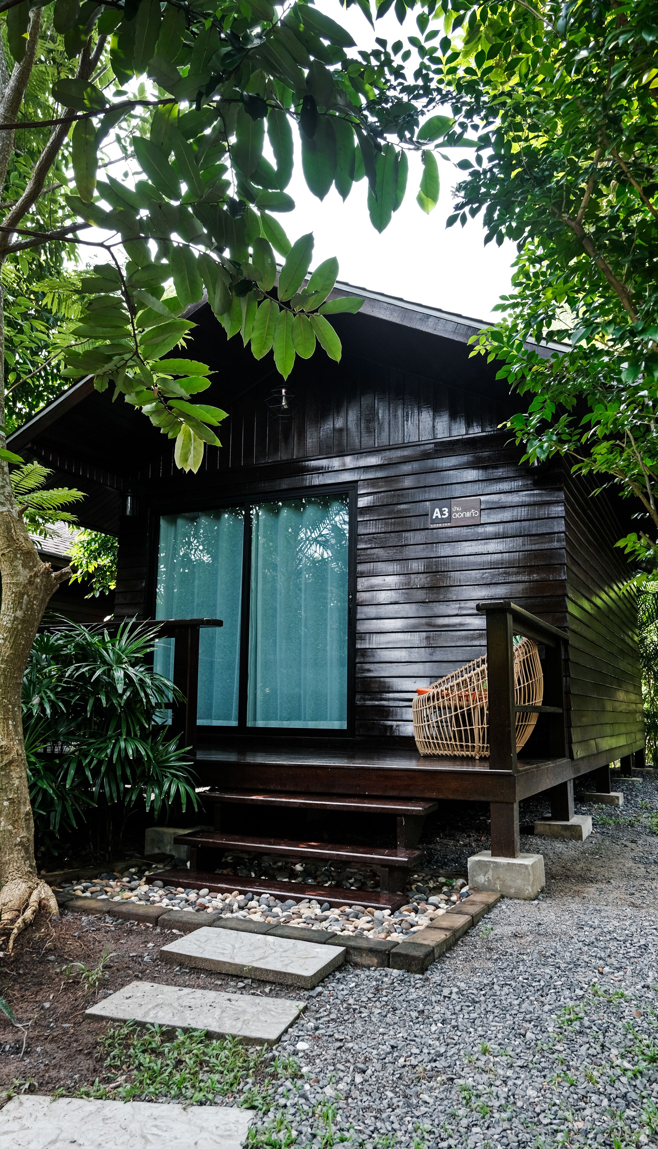 A wooden cabin with a large window, a small porch, and a sign reading 'A3'.