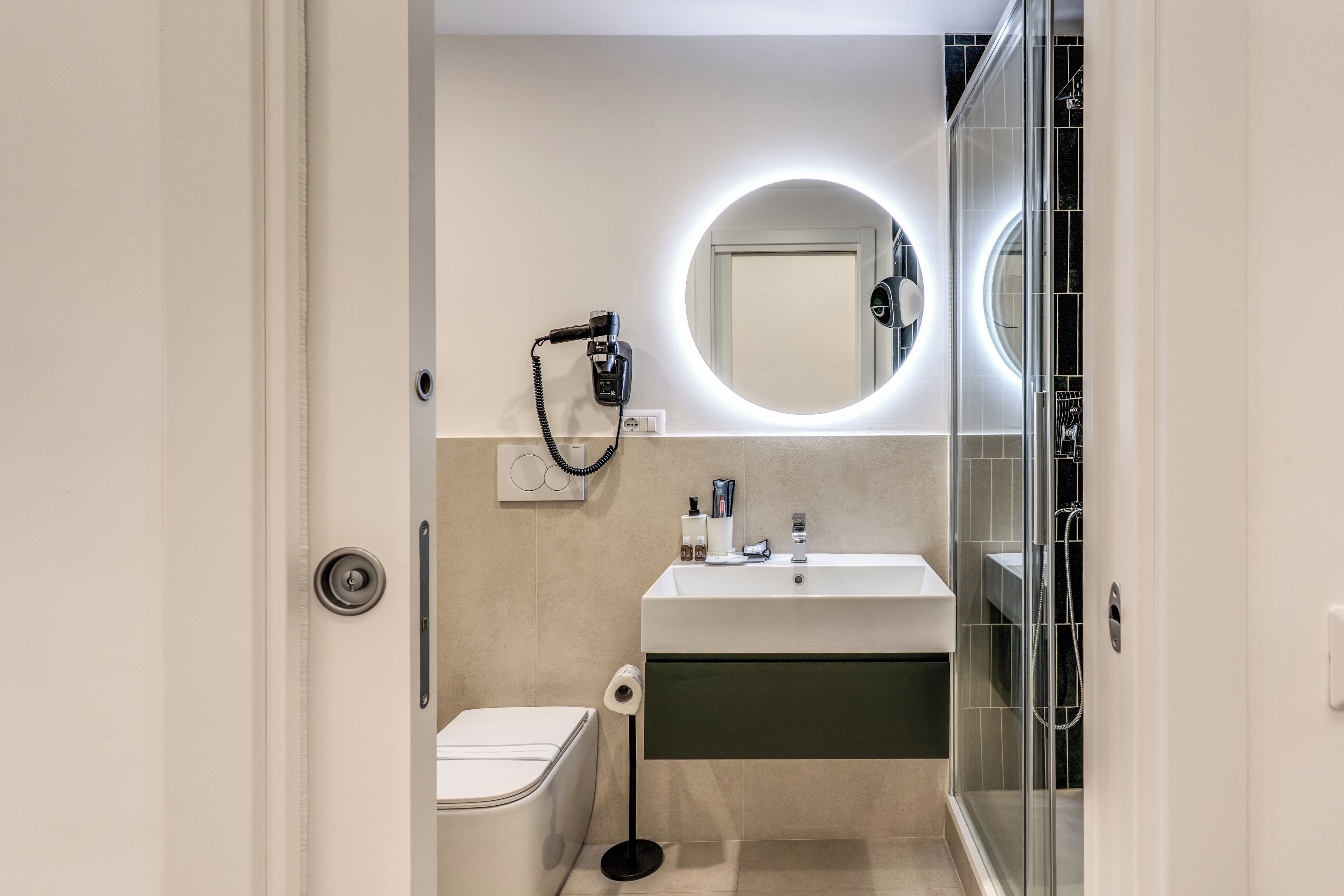A modern bathroom with a toilet, sink, and shower.