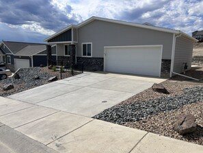 A residential house with a garage, driveway, and landscaping.