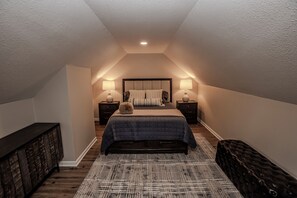 A bedroom with a bed, two bedside tables, a bench, and a ceiling light. - Downtown Delight 3bd 2bth with WiFi (Overland Park)