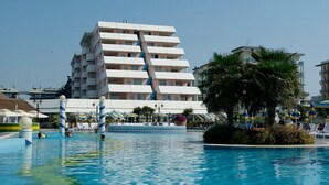 Un hôtel doté d’un espace piscine comprenant une grande piscine et des chaises longues.