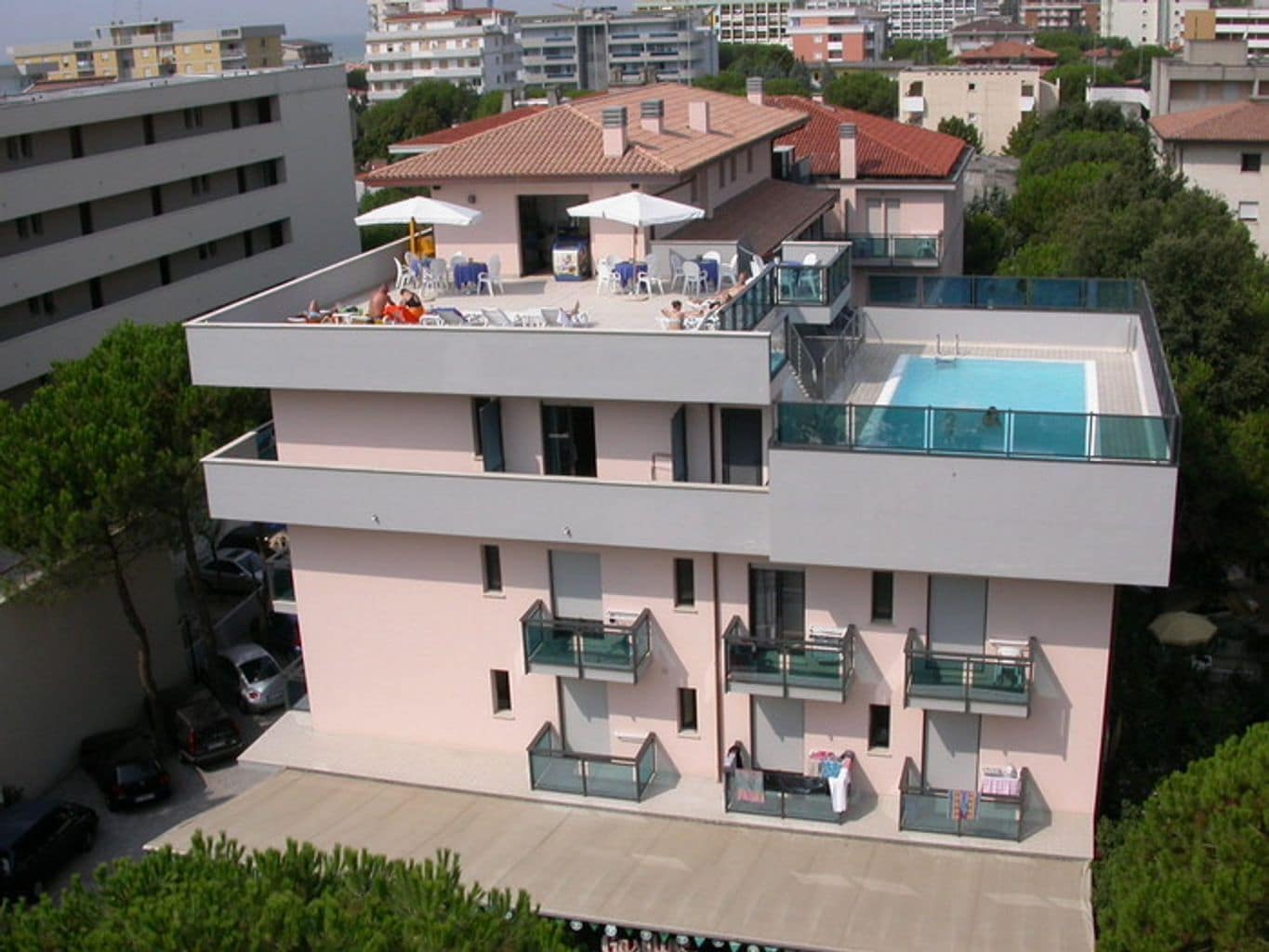 Un bâtiment moderne doté d’une piscine sur le toit et d’un espace extérieur aménagé pour se détendre.
