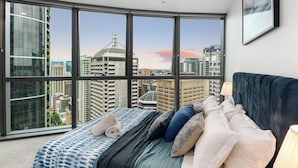 Une chambre avec une grande fenêtre, un lit et un ventilateur de plafond.