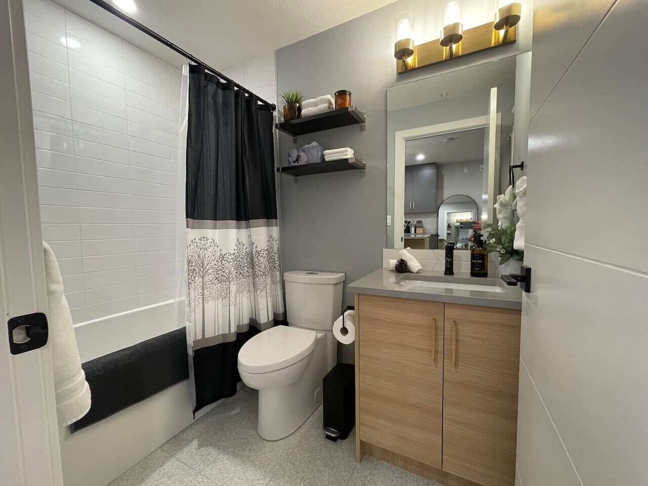 Un baño moderno con inodoro, lavamanos y zona de ducha.