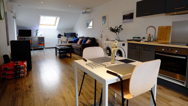 Un appartement moderne comprenant un coin repas, une cuisine et un salon.
