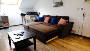 Un salon moderne avec un canapé, une table basse et un bureau avec un ordinateur.