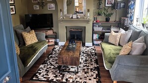 Ein Wohnzimmer mit Kamin, zwei Sofas, einem Couchtisch und einem Fernseher.