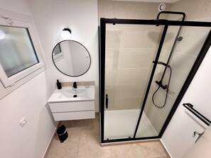 Een douche, een haardroger, handdoeken, toiletpapier
