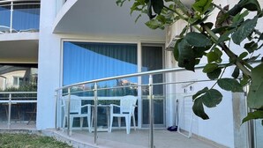 Un bâtiment moderne doté d’un balcon, d’un espace extérieur aménagé pour s’asseoir et d’un jardin.
