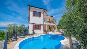 A two-story house with a swimming pool, outdoor furniture, and a view of the sea. - Relaxing Apartment With sea View and Jacuzzi (Rasa)