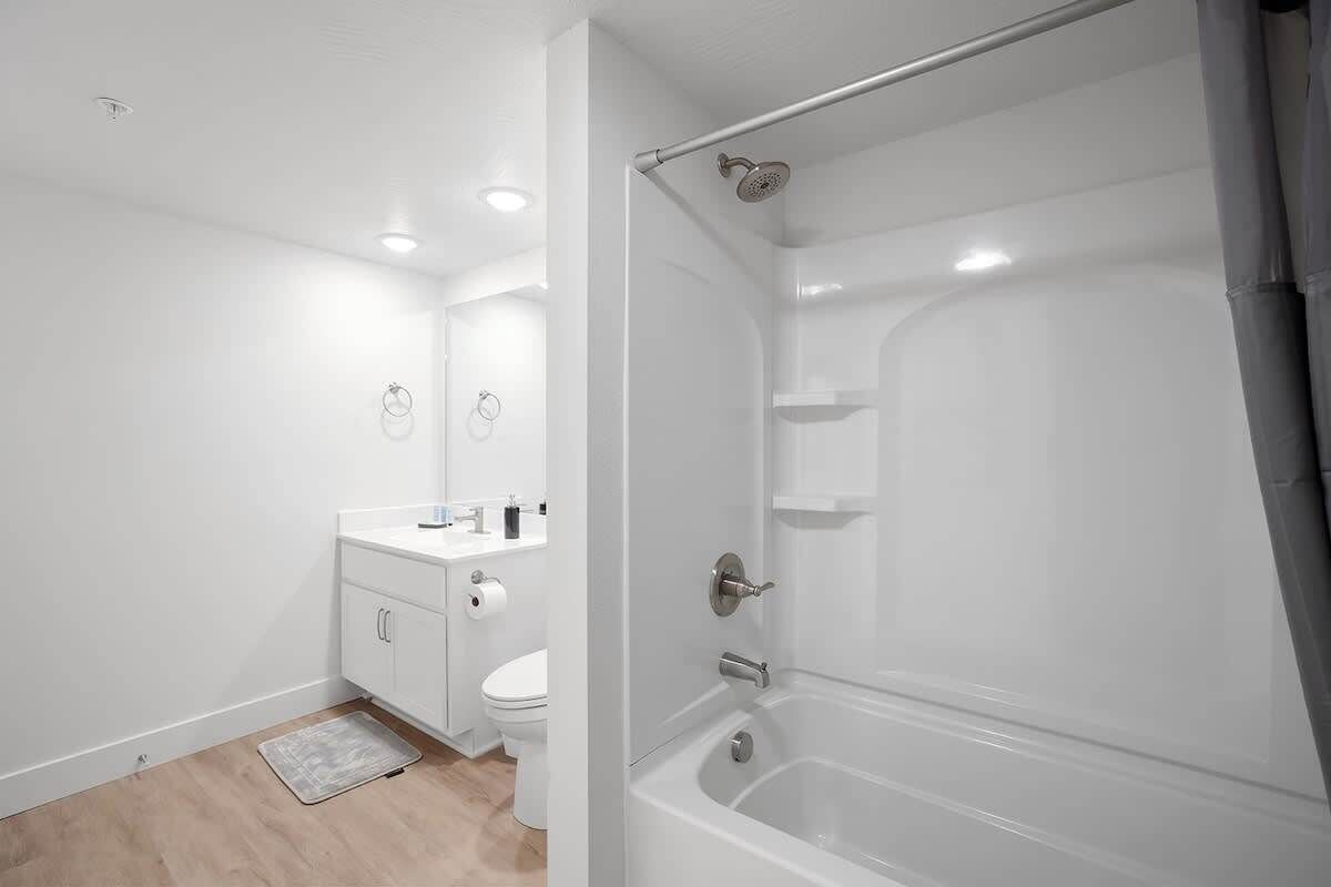 A modern bathroom with a bathtub, toilet, and sink.