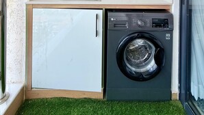 A compact kitchen with a built-in washing machine and a small sink. - One Bedroom Apartment in Kilimani, near Yaya Centre (Nairobi)