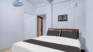 A bedroom with a bed, a wall-mounted fan, a door, and a framed picture. - Hotel O Lapalang Shillong (Shillong)
