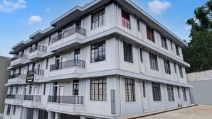 A multi-story hotel with balconies, large windows, and a sign indicating it is a hotel. - Hotel O Lapalang Shillong (Shillong)