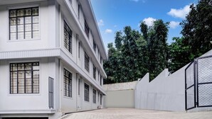 A multi-story building with large windows and a paved courtyard. - Hotel O Lapalang Shillong (Shillong)
