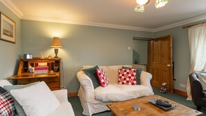 Ein gemütliches Wohnzimmer mit Sofa, Couchtisch und Lampe.
