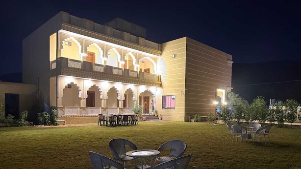Un bâtiment doté d’une cour intérieure, d’un espace extérieur aménagé pour s’asseoir et d’éléments architecturaux traditionnels.