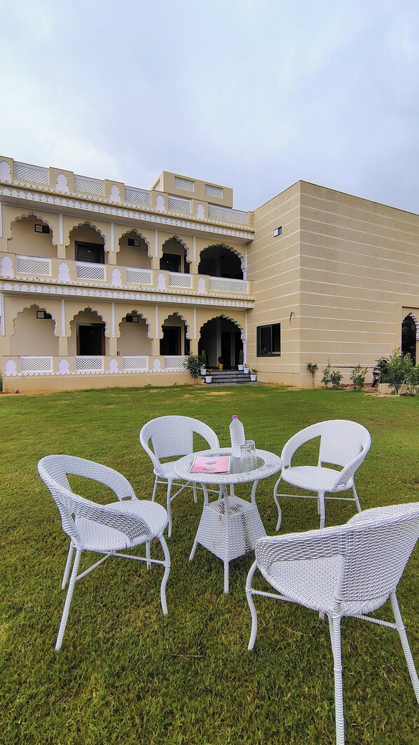 A traditional building with multiple balconies and a courtyard with wicker furniture. - Braham Niwas Resort (Pushkar)