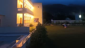 A modern building with a balcony and a well-lit entrance.