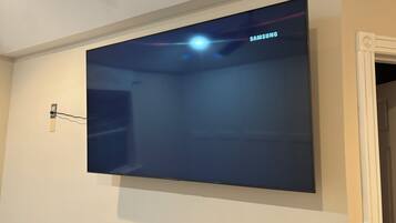 Televisão de tela plana montada na parede, com o logotipo da Samsung visível.