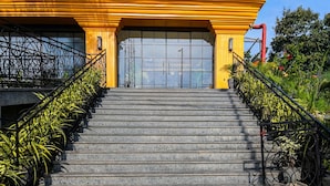 A staircase leading to a building with a yellow facade and a large glass door.