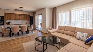 Una sala de estar moderna con sofá, mesa de centro y comedor.