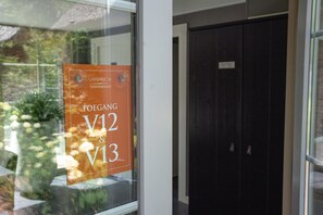 A sign on a glass door indicating room numbers V12 and V13. - Romantic Loft w/ Garden Terrace (Ermelo)