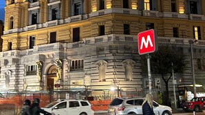 A multi-story building with classical architecture, featuring a prominent 'M' sign indicating a metro station.