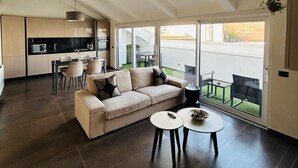A modern living room with a sofa, coffee table, and dining area.