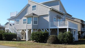 A two-story house with a balcony on the second floor and a covered front porch.