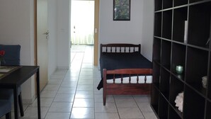 Une pièce comprenant un lit, un bureau et une étagère.