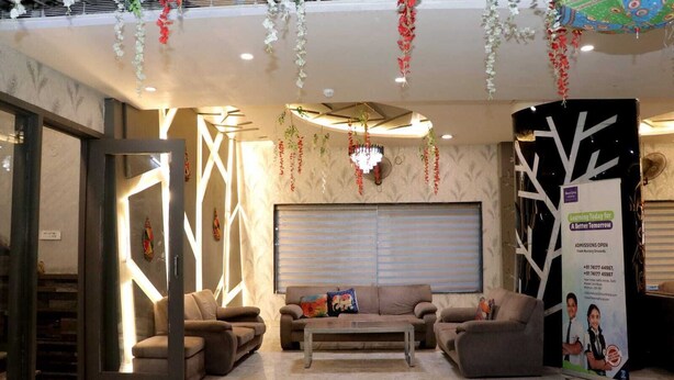 Un área de recepción con un sofá, sillas, una mesita de centro y una pared decorativa.