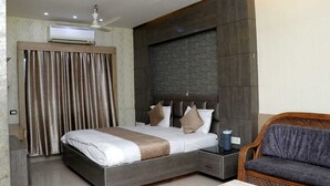 Una habitación de hotel moderna con cama, mesita de noche, silla y ventilador de techo.