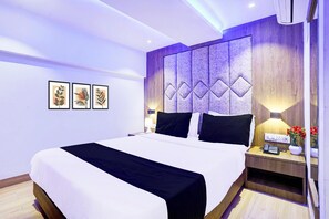 A modern hotel room with a large bed, a nightstand with a lamp, and wall-mounted artwork. - Pleasant Stays Near Powai Lake Mumbai (Mumbai)