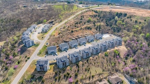 Una zona residencial con una hilera de casas modernas, una calle principal y una vista de una extensa masa de agua al fondo.