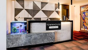 Un mostrador de recepción con un letrero que dice 'TOWNHOUSE', un acuario y una pared decorativa.